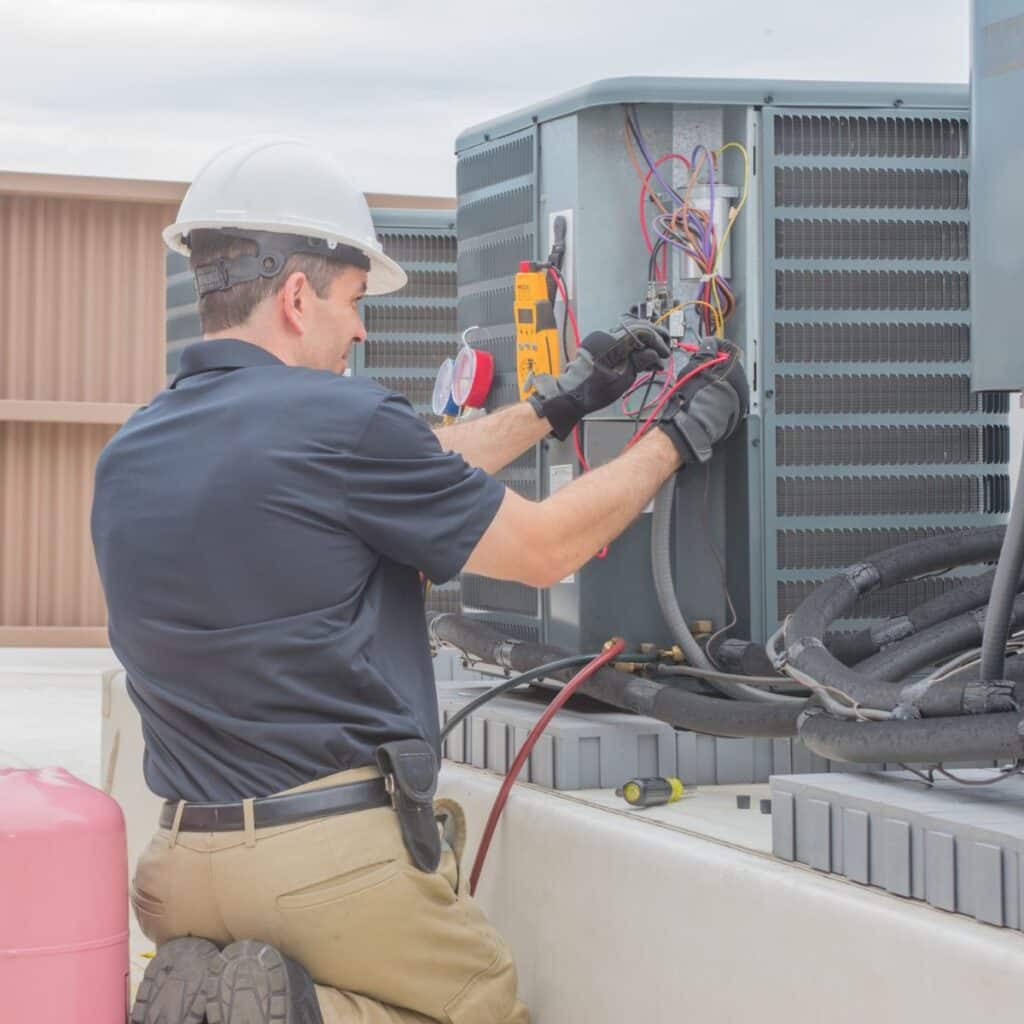 hvac technician performing repairs on commercial ac system
