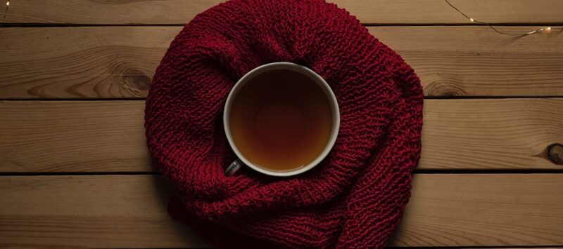 top view of a cup of tea sitting on a maroon blanket