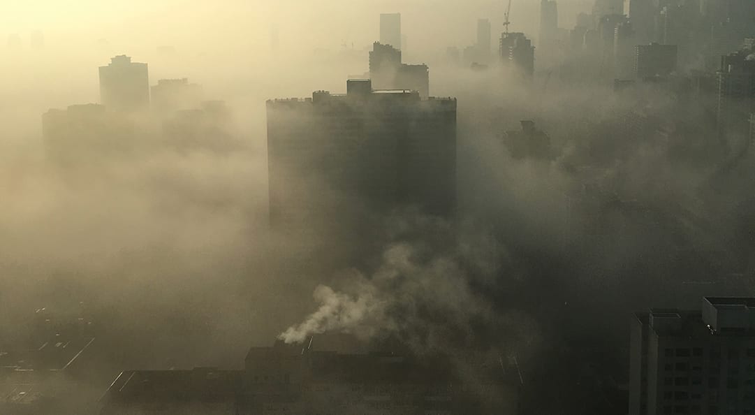 aerial view of city skyscraper buildings surrounded by polluted air
