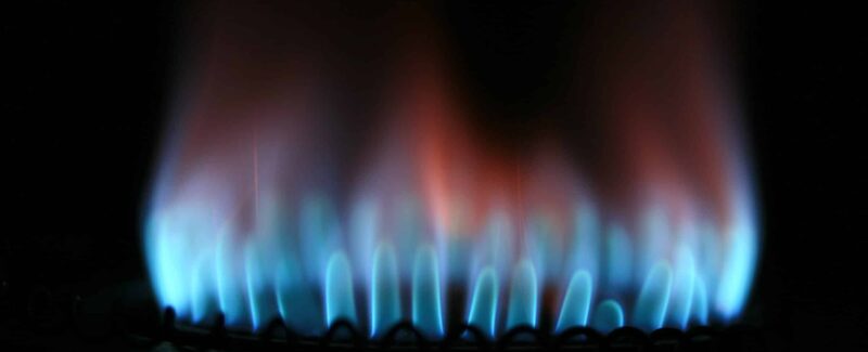 closeup of a blue flame from a gas furnace that fades into an orange flame