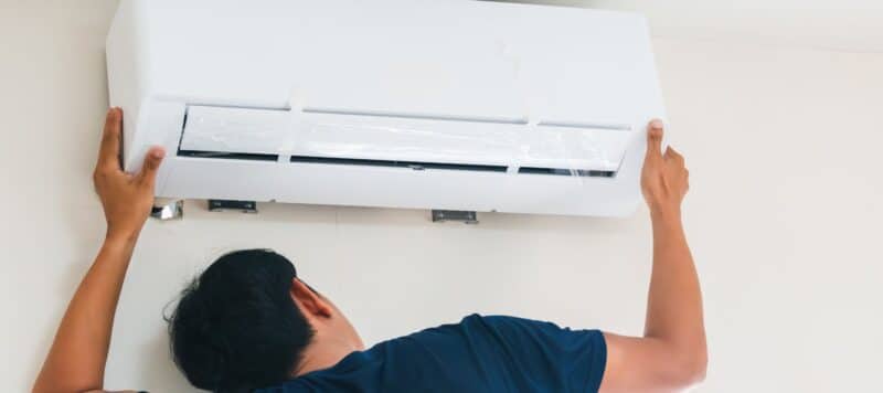 ac technician performing an inspection on a ductless ac unit