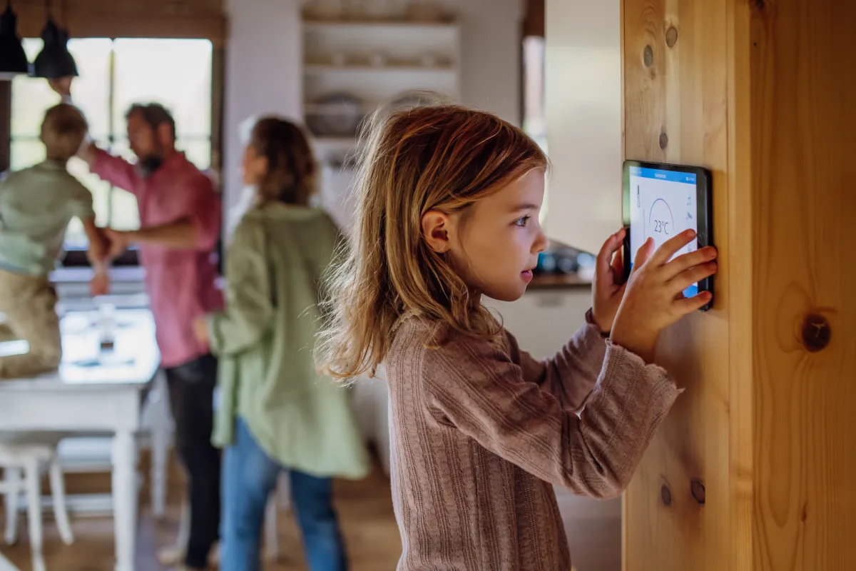 Little girl using a smart thermostat