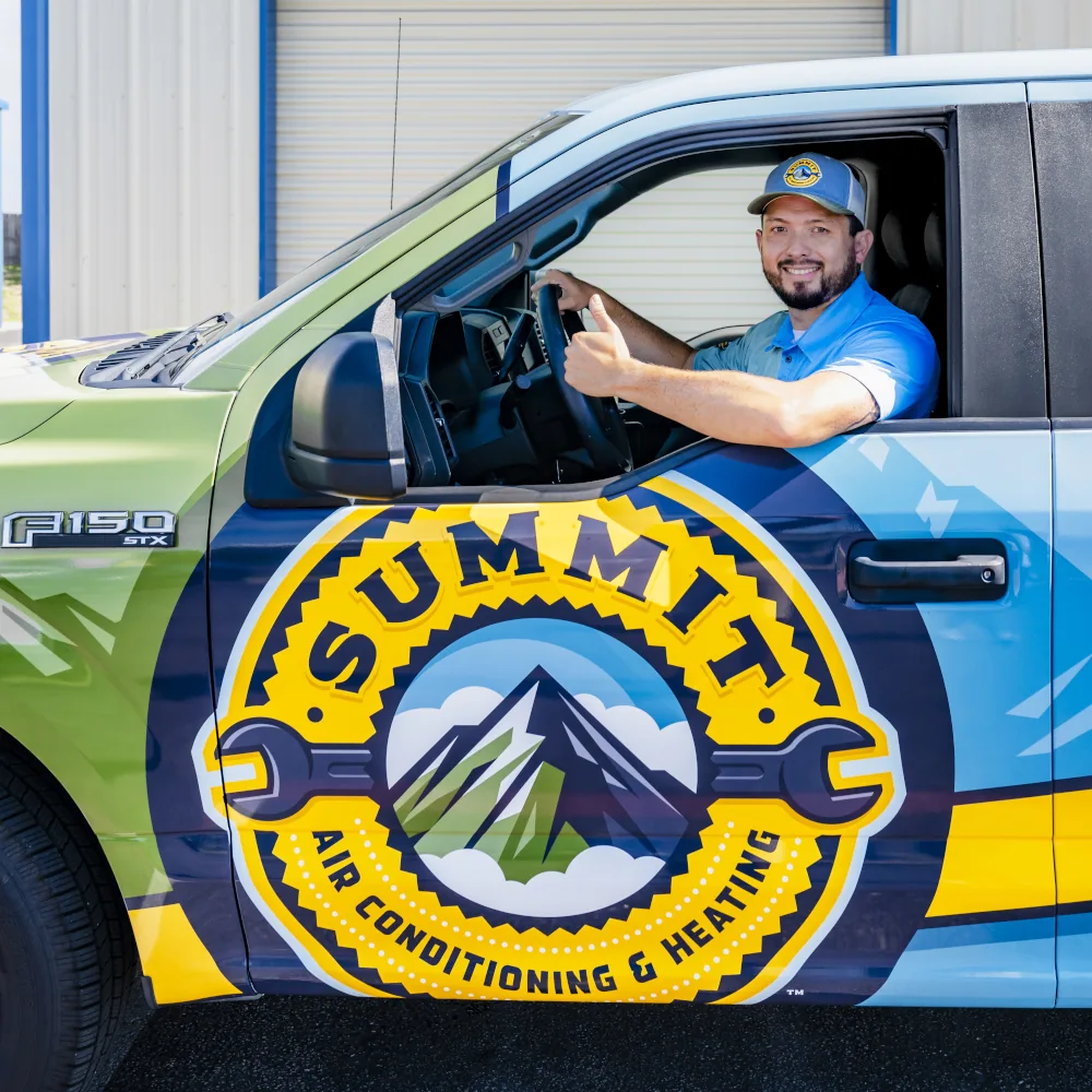 Summit AC crew member driving company truck and giving a thumbs up