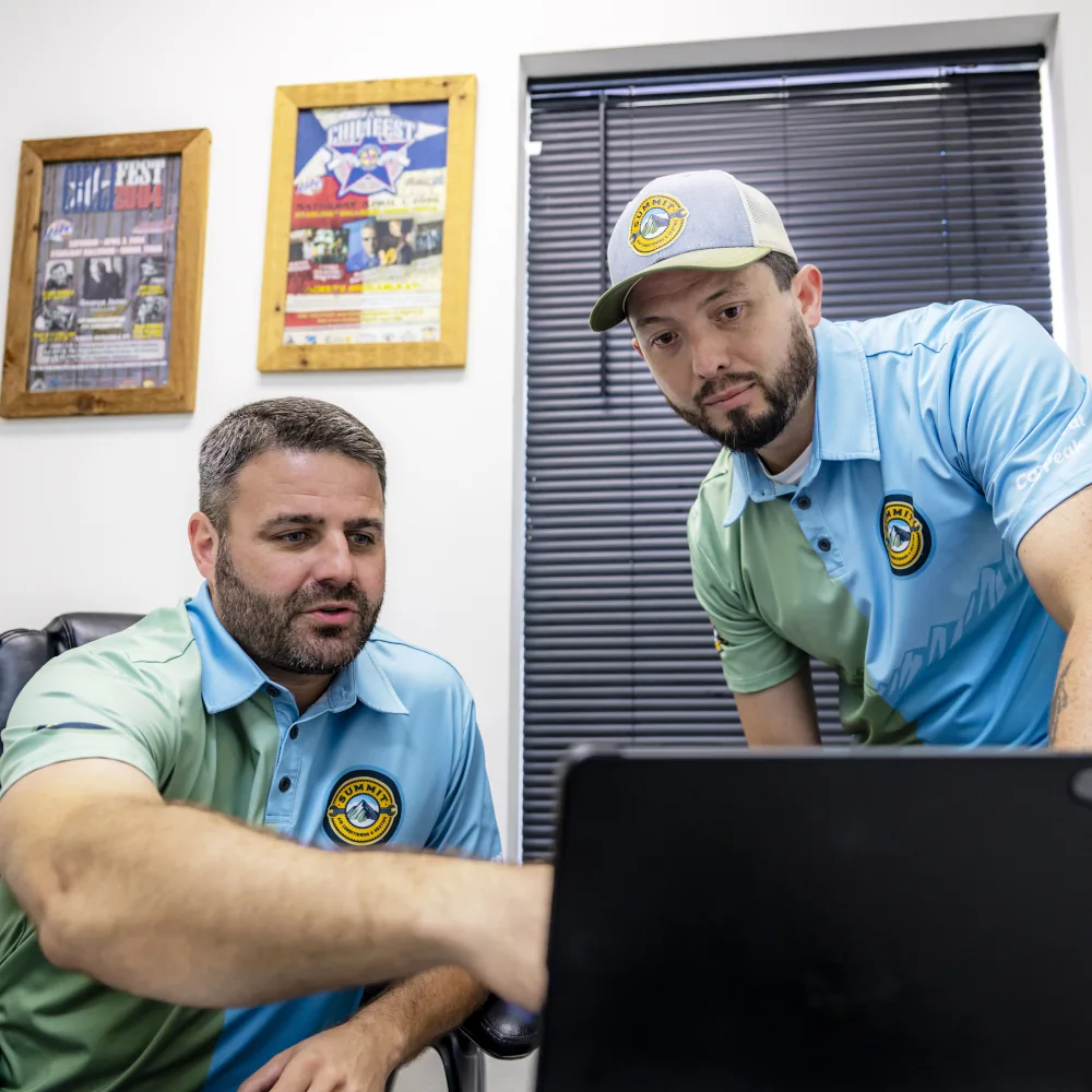 2 Summit AC crew members looking at a computer