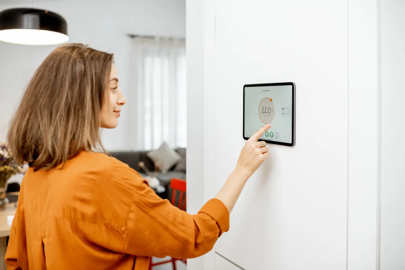 Woman using a smart thermostat